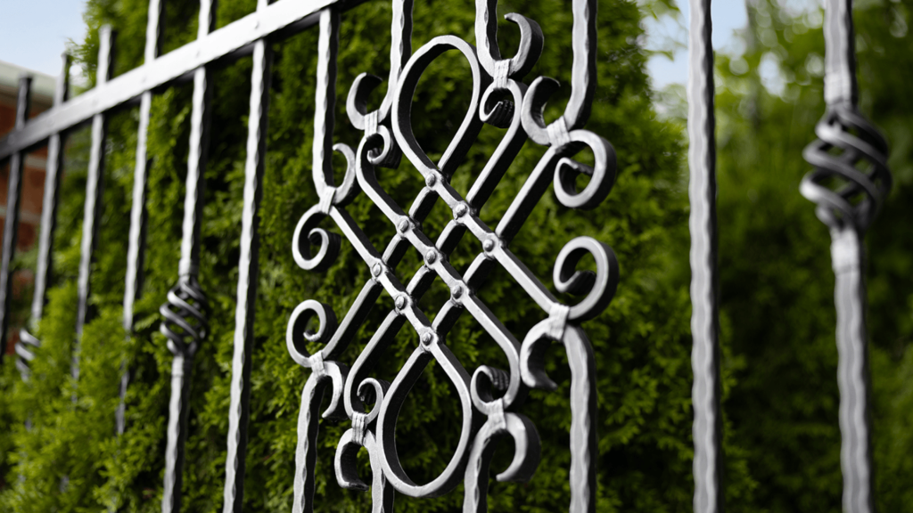 Detail designového kovaného plotu LAMARK s ozdobným prvkem NICE, precizní řemeslné zpracování a elegantní design.