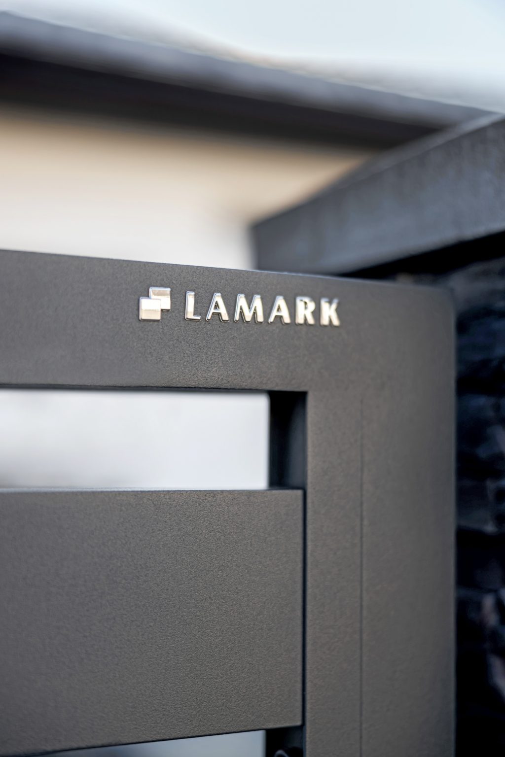 Detail loga LAMARK na deskovém plotě | Motiv Lobon | Šedá antracitová barva | Zděné sloupky