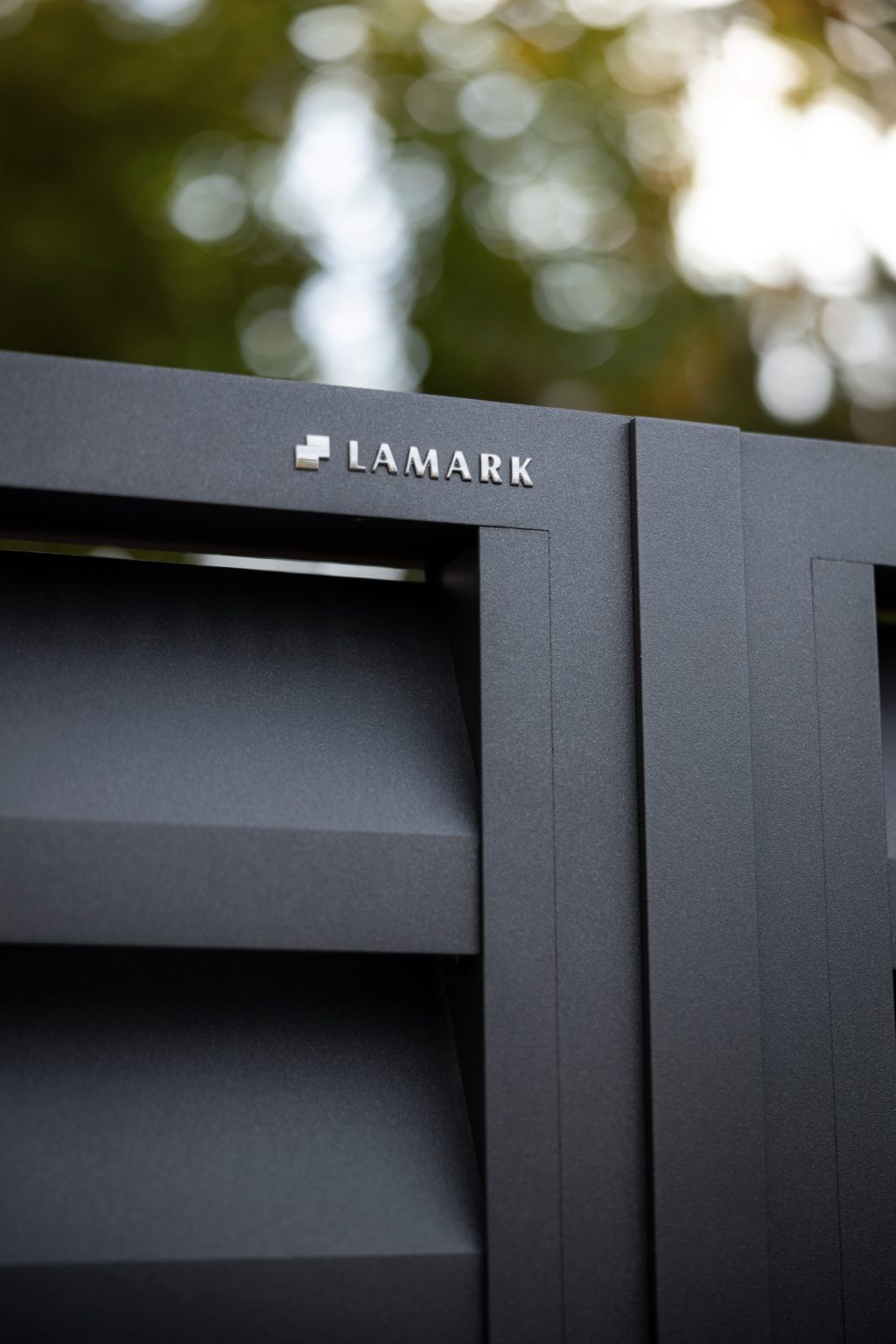 Detail loga LAMARK na hliníkové brance | Motiv Alicante | Šedá antracitová barva | Zděné sloupky a hliníkové sloupky LAMARK