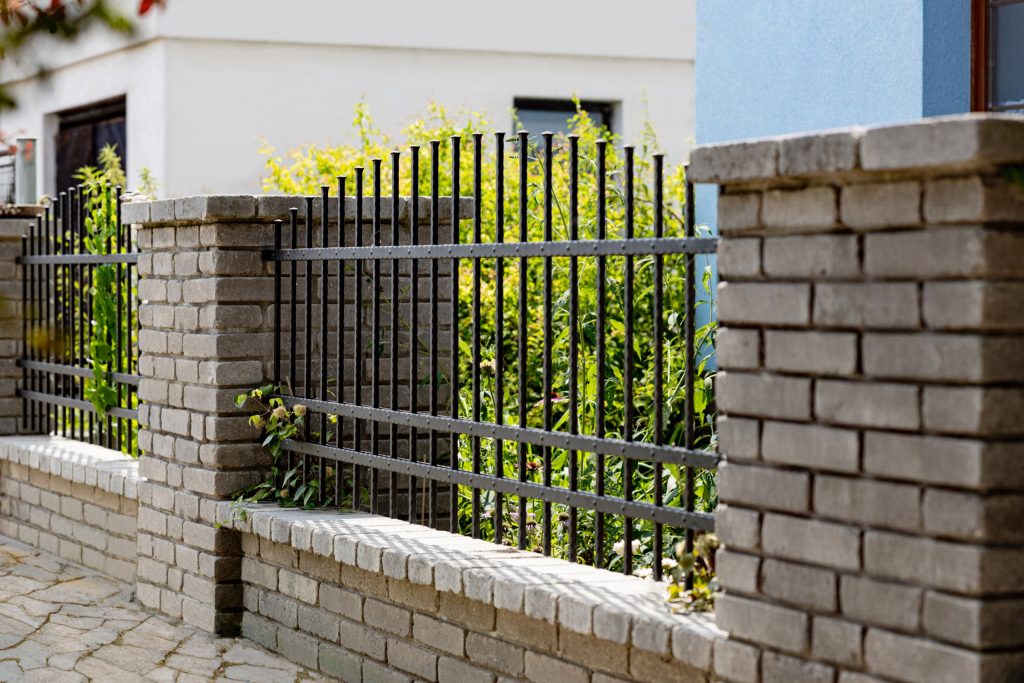 Kovaný plot LAMARK | Motiv Detroit | Černá kovářská barva | Měděná patina | Svařované s nýty | Oklepávané provedení | Okované konce | Zděné sloupky